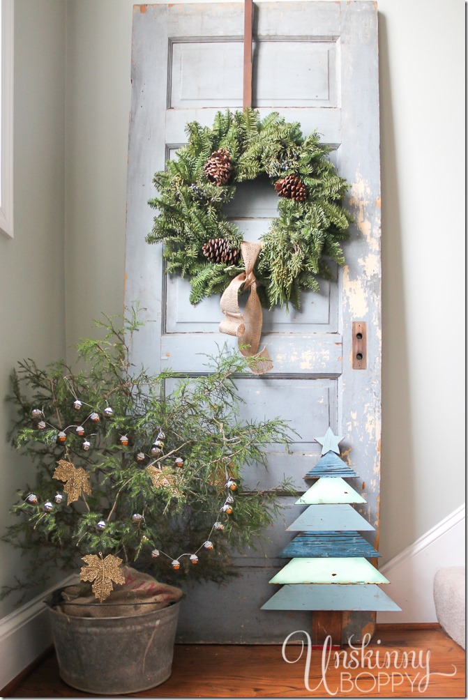 Gorgeous rustic Christmas decor. Tree in a galvanized bucket, chippy old door with a wreath, and a Christmas tree made from architectural salvaged wood.