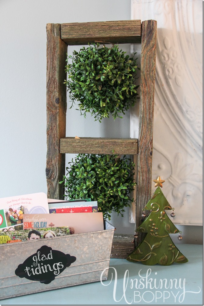 Boxwood kissing balls and "Glad Tidings" label on a galvanized bucket for Christmas cards