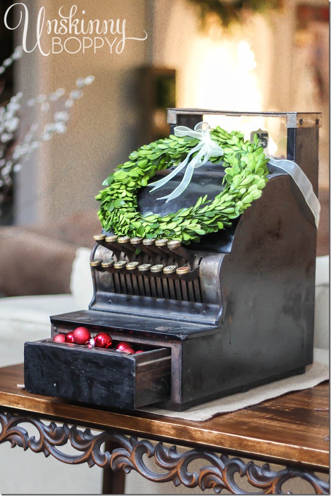 Vintage cash register filled with ornaments and set to "25" cents. Cute boxwood wreath, too! 