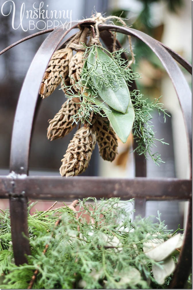 Fill a metal orb with evergreen branches and hang magnolia cones from the top. Pretty winter display