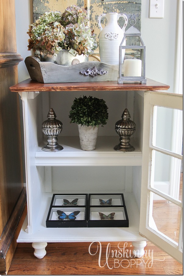 This end table  has a cabinet with shelves that are perfect for adding more decorative pieces to your end table design. Love the four butterflies on the bottom shelf!