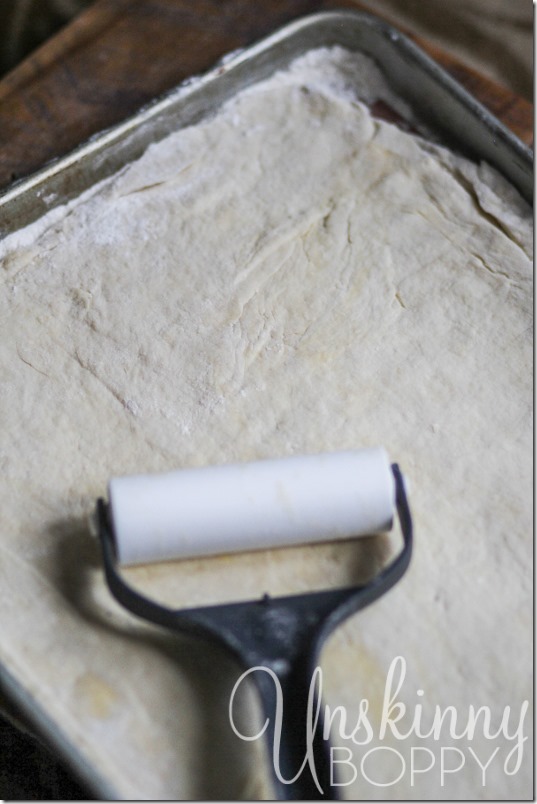 Lay the dough out on a floured cookie sheet and roll out flat.