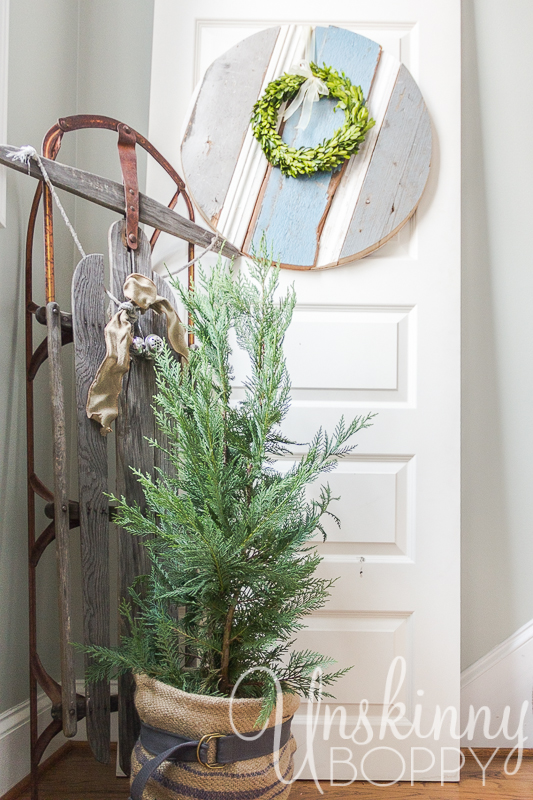 Old Sled with belted burlap tree and Christmas wreath. 