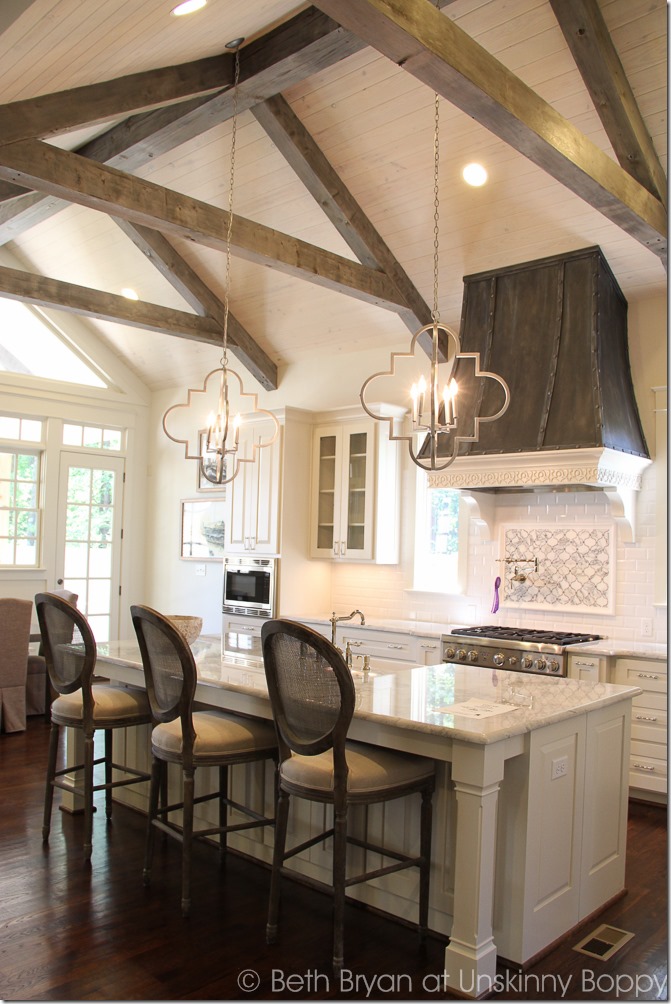 Incredible Kitchen with rustic ceiling beam and french style hood over range