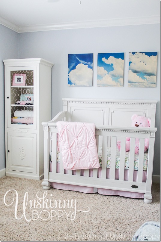 Simple nursery with cloud photos above crib