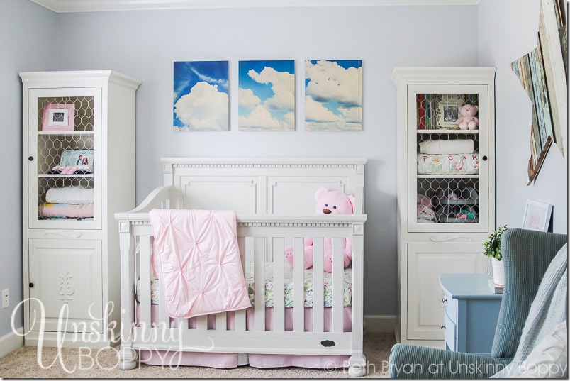 Simple nursery with cloud photos above crib
