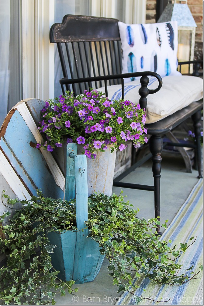 Black metal Front porch bench with watercolor feather pillow, french grain sack cushion and flowers in a bucket for Spring | Cozy Spring Home Tour | www.unskinnyboppy.com