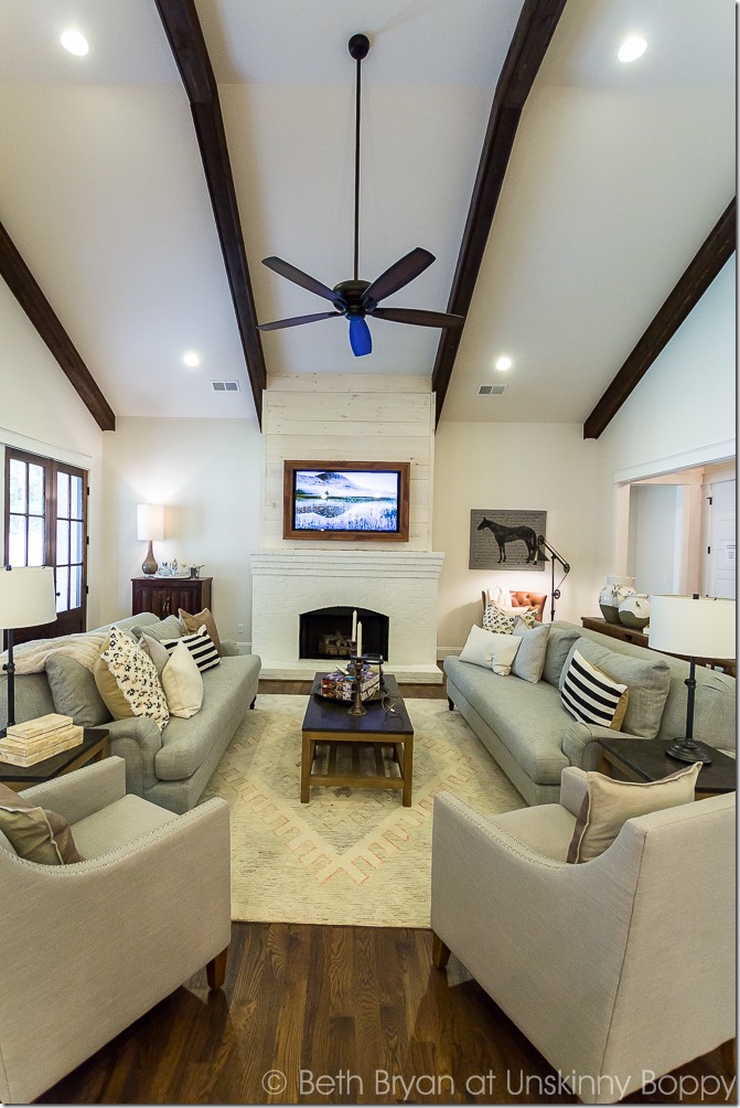 ceiling beams in living room with shiplap fireplace