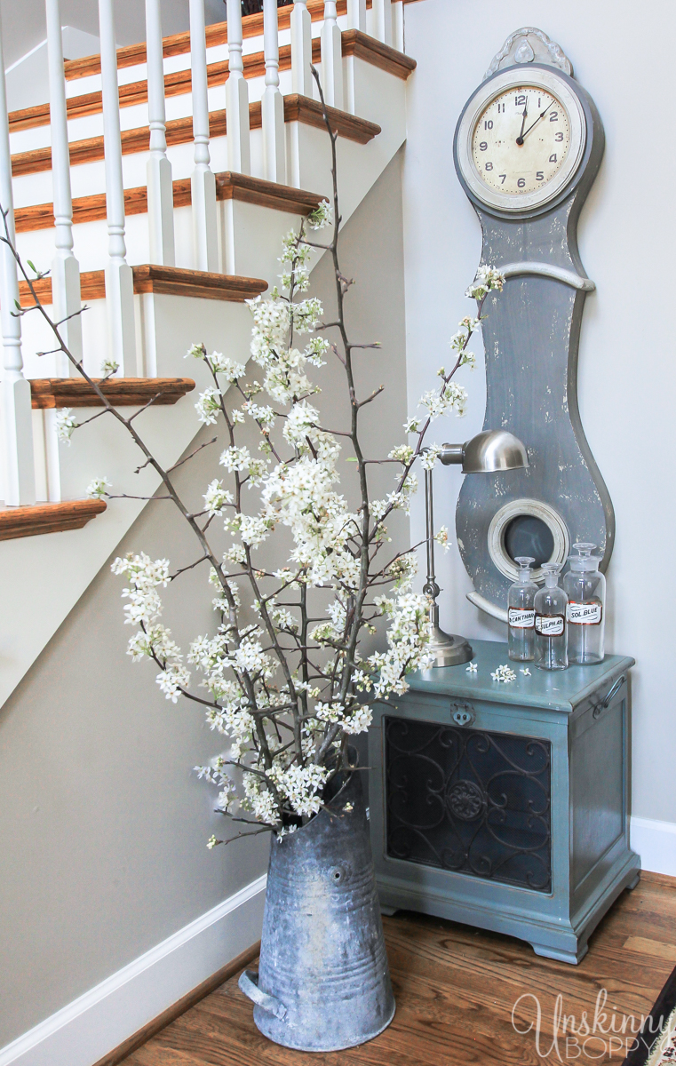 Pretty Spring home decor ideas- Mora swedish clock and a coal bucket full of blooms.