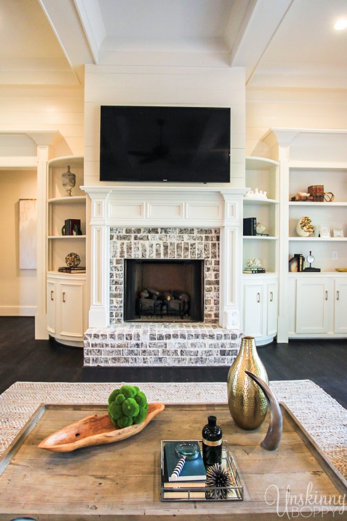 Rounded built-ins beside fireplace with coffered ceiling