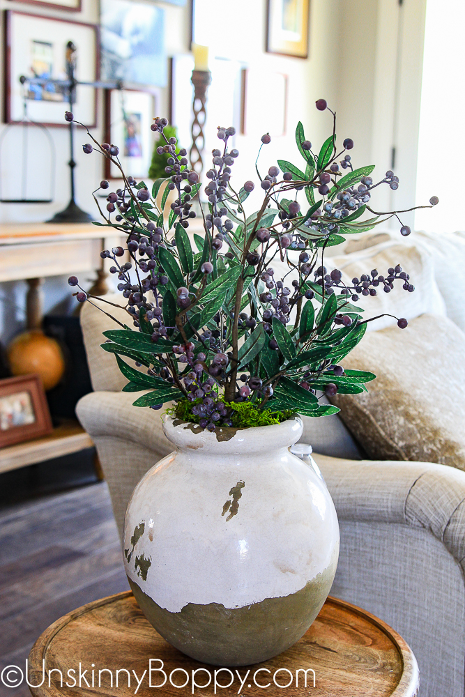 Fake blueberry stems in an olive jar