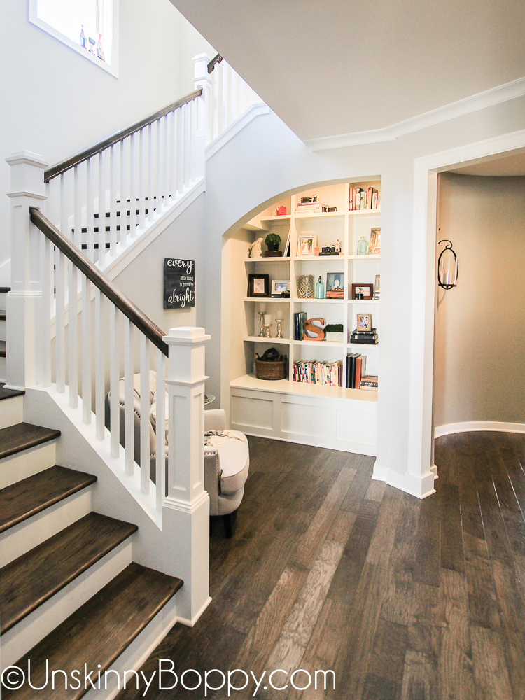 Grand staircase with built-in bookcase nook and circular hallway