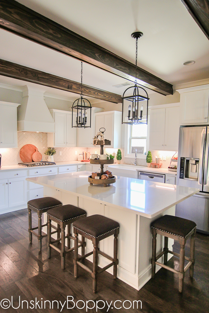 White kitchen cabinets with wooden beams