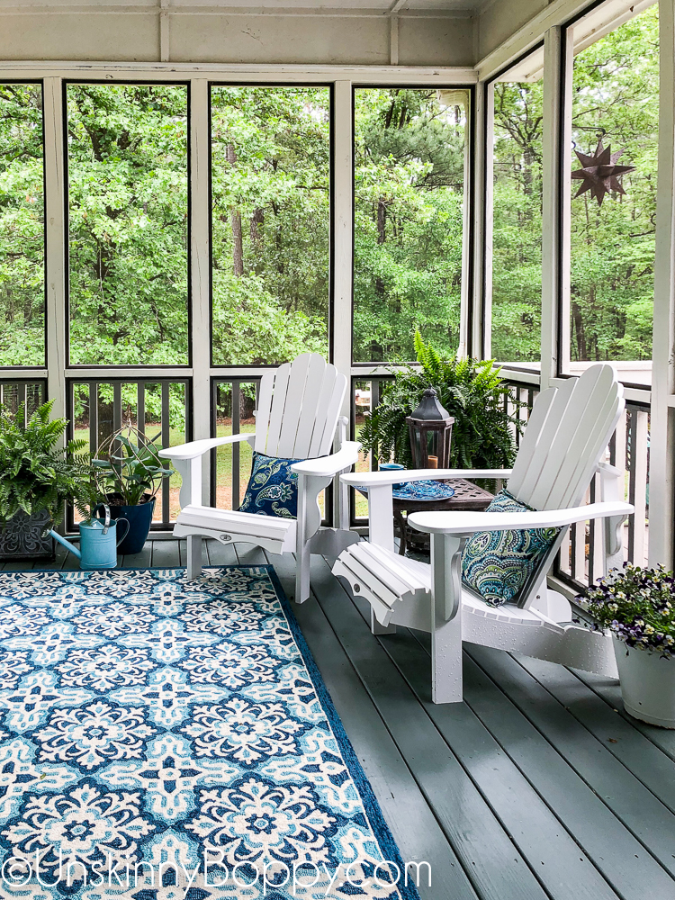 Screened in porch decor with white adirondack chairs and green/ aqua/ blue rug