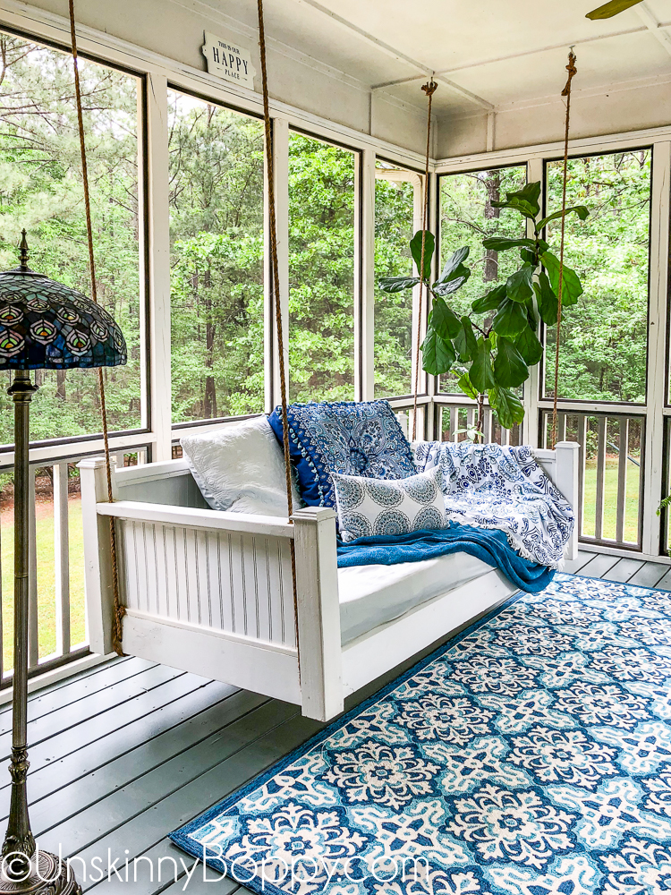 Swinging Day Bed on a screened in back porch with blue and white accents