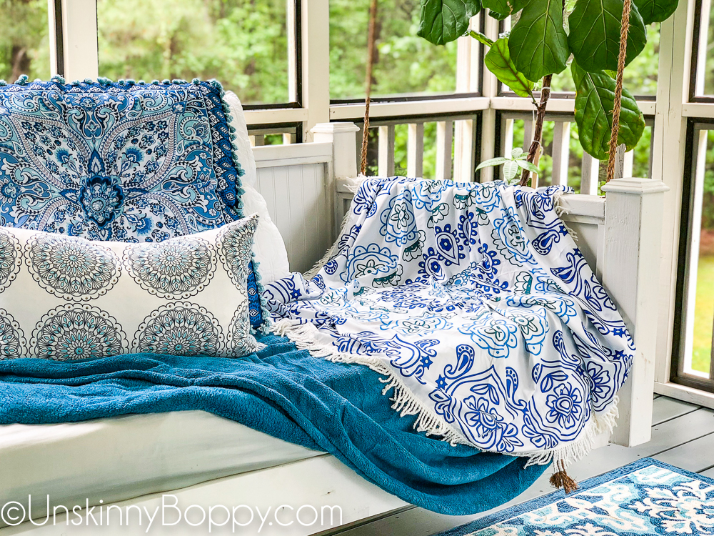 Blue mandala pillow from TJMaxx on a white bed swing