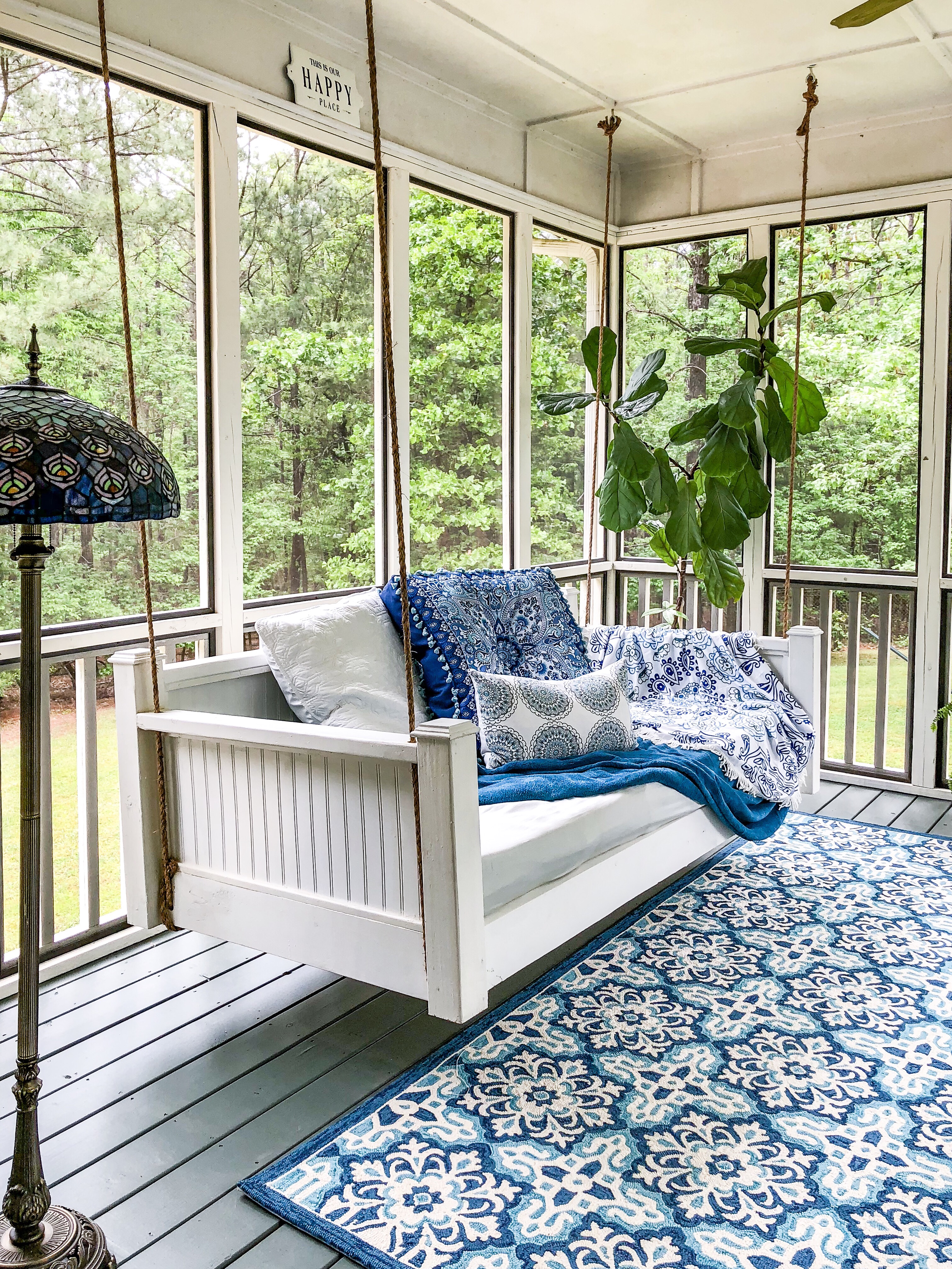 White beadboard bed swing on back porch