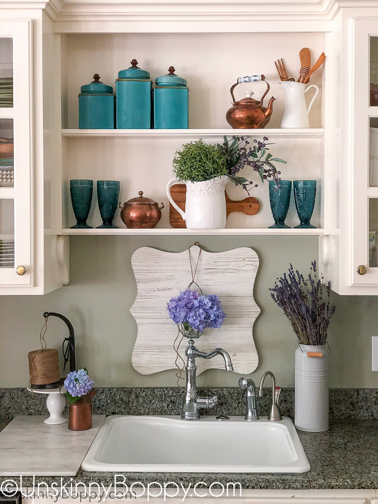 Decorating shelves above kitchen sink with copper and blues