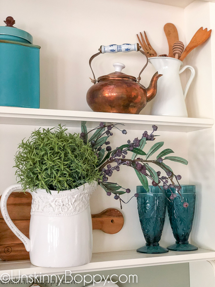 Decorating shelves above kitchen sink with copper and blues