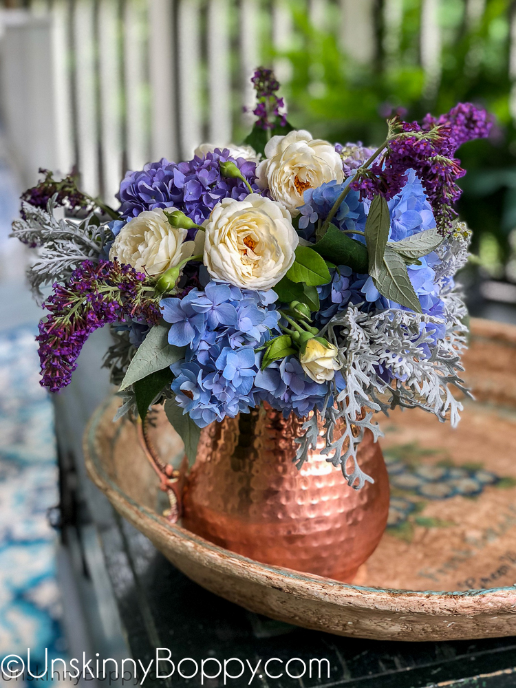 Periwinkle Hydrangea and white rose bouquet in a copper pitcher
