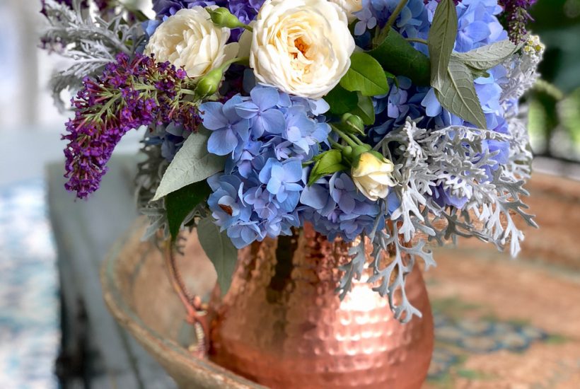 Periwinkle Hydrangea and white rose bouquet in a copper pitcher