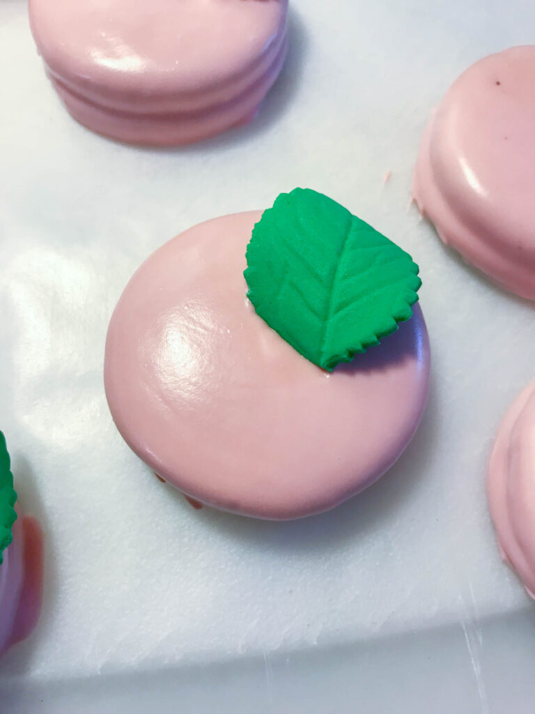 adding leaf onto oreo for bridal shower dessert