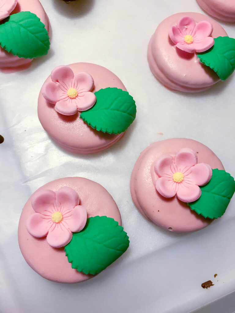 adding edible flowers onto Oreos