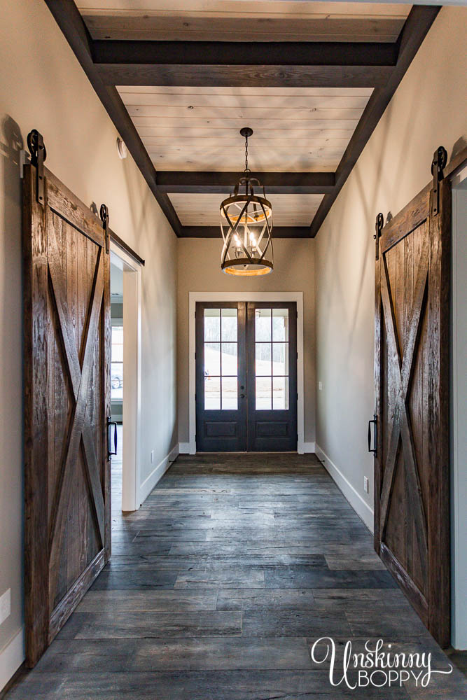 Foyer entrance with barn doors and dark wood ceiling