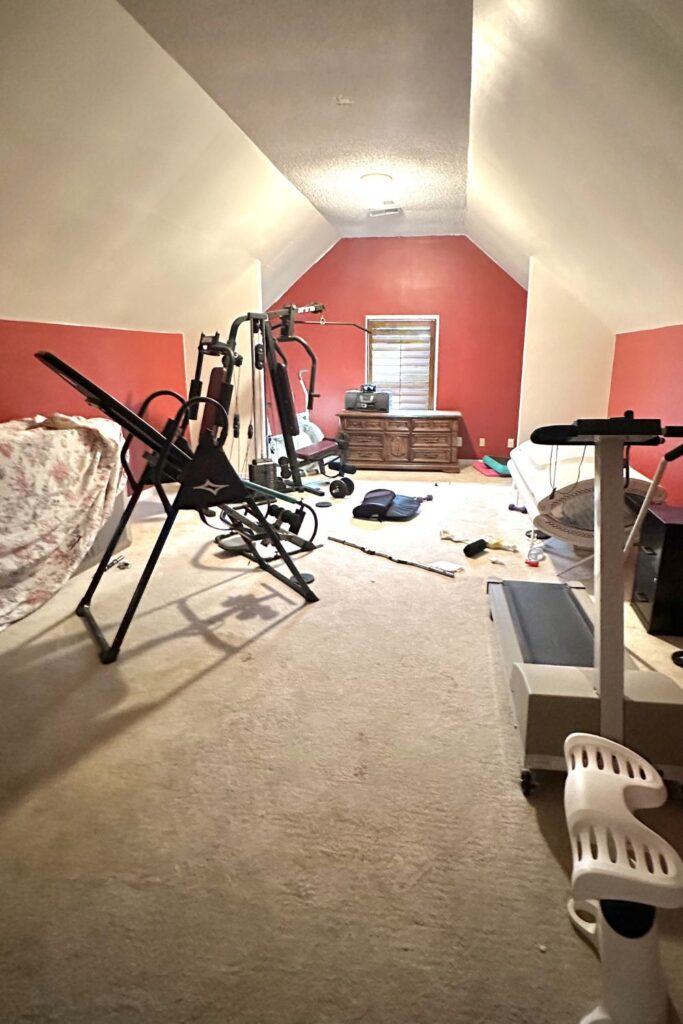 attic before conversion with tanning bed and workout equipment before being turned into a bunk room