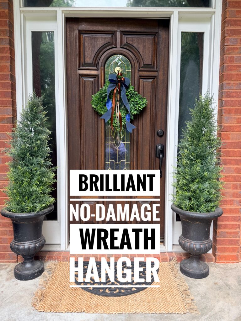 No-Damage Wreath Hanging Solution - wreath on front door flanked by cedar topiary trees